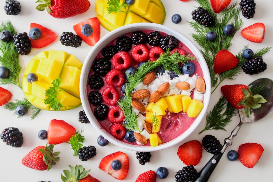 A vibrant, healthy fruit smoothie bowl topped with fresh berries, mango, and almonds.